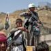 TOPSHOT - A Yemeni boy lines up a round of ammunition atop the barrel of a Kalashnikov assault rifle, with a flag sticking from his jacket showing a picture of the Huthi rebel leader Abdulmalik al-Huthi, while another buy stands with Kalashnikov over a crate of juice boxes during a tribal meeting in the Huthi rebel-held capital Sanaa on September 21, 2019, as tribesmen donate rations and funds to fighters loyal to the Huthis along the fronts. (Photo by MOHAMMED HUWAIS / AFP)        (Photo credit should read MOHAMMED HUWAIS/AFP via Getty Images)