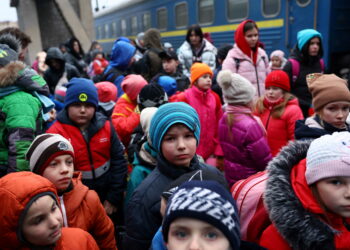 A group of children evacuated from an orphanage in Zaporizhzhia wait to board a bus for their transfer to Poland after fleeing the ongoing Russian invasion at the main train station in Lviv, Ukraine, March 5, 2022.   REUTERS/Kai Pfaffenbach REFILE - CORRECTING INFORMATION