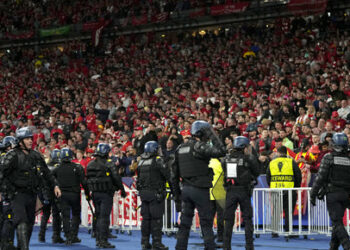 Riot police watch Liverpool fans during the Champions League final soccer match between Liverpool and Real Madrid at the Stade de France in Saint Denis near Paris, Saturday, May 28, 2022. (AP Photo/Manu Fernandez)