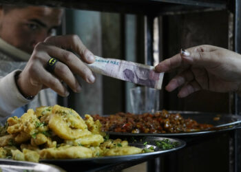 A man buys food at a popular restaurant in Cairo, Egypt, Tuesday, March 22, 2022. Egypt's Central Bank raised its key interest rate Monday for the first time since 2017, citing inflationary pressures triggered by the coronavirus pandemic and Russia's war in Ukraine. The move saw the Egyptian pound slip, trading at over 18 to the dollar — up from an average of 15.6 pounds for $1. That was likely to take a heavy toll on poor and middle-class Egyptians. (AP Photo/Amr Nabil)