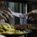 A man buys food at a popular restaurant in Cairo, Egypt, Tuesday, March 22, 2022. Egypt's Central Bank raised its key interest rate Monday for the first time since 2017, citing inflationary pressures triggered by the coronavirus pandemic and Russia's war in Ukraine. The move saw the Egyptian pound slip, trading at over 18 to the dollar — up from an average of 15.6 pounds for $1. That was likely to take a heavy toll on poor and middle-class Egyptians. (AP Photo/Amr Nabil)