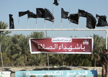 A member of Saudi security forces stands guard during the funeral of four people, who were killed in an attack at a Shi'ite Muslim mosque on Friday January 29, in Saudi Arabia's al-Ahsa district in Eastern Province February 1, 2016. The banner reads: "To heaven and paradise, oh martyrs of prayers", in a reference to those who died while praying. Picture taken February 1, 2016. REUTERS/Zuhair Al-Traifi