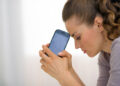 Portrait of stressed young woman with cell phone