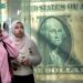 خبراء اقتصاد دوليون : انتظروا ارتفاع "قياسي" جديد للتضخم فى مصر 8 FILE - Egyptians walk past a poster depicting a U.S. dollar outside an exchange office in Cairo, Egypt, Thursday, Feb. 9, 2023. Egypt’s annual inflation rate set a record high in June, as the most populous Arab country continues to battle price hikes and a depreciating currency, the Egyptian statistics bureau said Monday, July 10, 2023. (AP Photo/Amr Nabil, File)