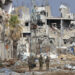 Israeli troops walk past destroyed buildings along the Salaheddine road which links the northern Gaza Strip with the south in the Zeitoun district on the outskirts of Gaza City on November 28, 2023. A truce between Israel and Hamas entered a fifth day on November 28 after the deal was extended to allow further releases of Israeli hostages and Palestinian prisoners. (Photo by MAHMUD HAMS / AFP)