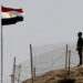 An Egyptian soldier stands near the Egyptian national flag and the Israeli flag at the Taba crossing between Egypt and Israel, about 430 km (256 miles) northeast of Cairo, October 26, 2011. Israel and Egypt said on Monday they have struck a deal to swap 25 Egyptians in Israeli custody for a U.S.-Israeli dual national accused by Cairo of espionage, in a step seen as easing strains between the strategic neighbors. REUTERS/Mohamed Abd El-Ghany  (EGYPT - Tags: CIVIL UNREST POLITICS)