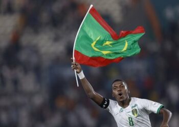 Mauritania's midfielder #8 Bodda Mouhsine holds a Mauritania flag after his team won the Africa Cup of Nations (CAN) 2024 group D football match between Mauritania and Algeria at Stade de la Paix in Bouake on January 23, 2024. (Photo by KENZO TRIBOUILLARD / AFP)
