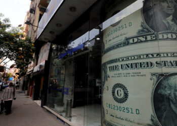 A woman walks past a currency exchange bureau advertisement showing images of the U.S. dollar in Cairo, Egypt, December 17, 2019. REUTERS/Amr Abdallah Dalsh