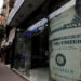 A woman walks past a currency exchange bureau advertisement showing images of the U.S. dollar in Cairo, Egypt, December 17, 2019. REUTERS/Amr Abdallah Dalsh