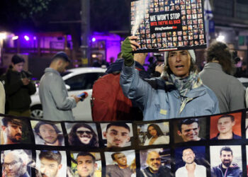 FILE PHOTO: A person holds a placard, as families of hostages and supporters protest to call for the immediate release of hostages kidnapped during the deadly October 7 attack by Palestinian Islamist group Hamas, outside Israeli Prime Minister Benjamin Netanyahu residence, in Jerusalem January 21, 2024. REUTERS/Ronen Zvulun/File Photo