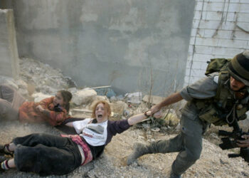 ** FOR USE AS DESIRED WITH YEAR END--FILE **In this Dec. 4, 2008 file photo, an Israeli police officer drags two Jewish settlers during the evacuation of a disputed house in the West Bank city of Hebron.  (AP Photo/Sebastian Scheiner/FILE)