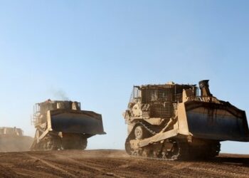 This picture taken from Israel's southern border with the Gaza Strip shows Israeli army bulldozers rolling along the border with the Palestinian territory on April 17, 2024, amid the ongoing conflict between Israel and the militant group Hamas. (Photo by JACK GUEZ / AFP)