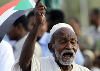 A supporter of Sudan's President Omar Hassan al-Bashir waves a flag during a national rally in Khartoum May 01, 2010. Bashir won Sudan's first open elections in 24 years. REUTERS/Mohamed Nureldin (Sudan - Tags: ELECTIONS POLITICS)