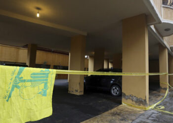 A Hezbollah flag is seen near the crime scene where commander Hasan al-Laqqis was killed in the southern Hadath district in Beirut December 4, 2013. Lebanon's Shi'ite militant Hezbollah group said on Wednesday al-Laqis was killed outside his Beirut home in an overnight attack it blamed on Israel. Israel denied any role in the killing, which Hezbollah said took place at around midnight in the southern Hadath district of the Lebanese capital. REUTERS/Hasan Shaaban (LEBANON - Tags: POLITICS CIVIL UNREST)