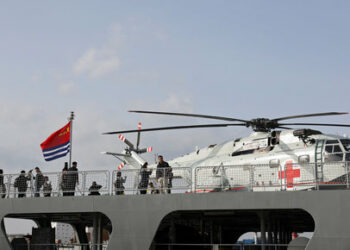 Visitors stand near a transport helicopter on the Kekexilihu, a Type 903 comprehensive supply ship, as the Chinese People's Liberation Army (PLA) Navy opens warships for public viewing to mark its upcoming 75th founding anniversary, at the port in Qingdao, Shandong province, China April 20, 2024. REUTERS/Florence Lo