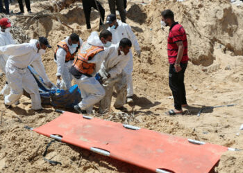 People work to move into a cemetery bodies of Palestinians killed during Israel's military offensive and buried at Nasser hospital, amid the ongoing conflict between Israel and the Palestinian Islamist group Hamas, in Khan Younis in the southern Gaza Strip, April 21, 2024. REUTERS/Ramadan Abed