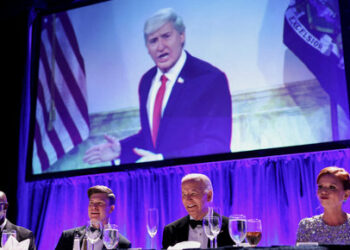 U.S. President Joe Biden reacts while sitting next to host Colin Jost and White House Correspondents' Association (WHCA) President and NBC News Senior White House Correspondent Kelly O'Donnell, during the White House Correspondents' Association Dinner, in Washington, U.S., April 27, 2024. REUTERS/Tom Brenner