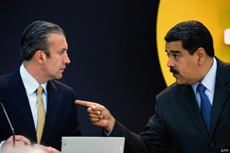 Venezuela's President Nicolas Maduro (R) speaks with Vice-President Tarek El Aissami during a press conference to launch to the market a new oil-backed cryptocurrency called "Petro", at the Miraflores Presidential Palace in Caracas, on February 20, 2018. - Venezuela formally launched its new oil-backed cryptocurrency on Tuesday in an unconventional bid to haul itself out of a deepening economic crisis. The leftist Caracas government put 38.4 million units of the world's first state-backed digital currency, the Petro, on private pre-sale from the early hours. A total of 100 million Petros will go on sale, with an initial value set at $60, based on the price of a barrel of Venezuelan crude in mid-January. (Photo by FEDERICO PARRA / AFP)