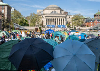 People use umbrellas to block members of the media from documenting the encampment at the Columbia University campus, during the ongoing conflict between Israel and the Palestinian Islamist group Hamas, in New York City, U.S., April 26, 2024. REUTERS/David Dee Delgado