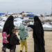 Displaced Syrian women and a children walk toward tents at the Internally Displaced Persons (IDP) camp of al-Hol in al-Hasakeh governorate in northeastern Syria,on February 7, 2019. (Photo by FADEL SENNA / AFP)