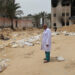 A doctor stands near bodies lined up for identification after they were unearthed from a mass grave found in the Nasser Medical Complex in the southern Gaza Strip on April 25, 2024, amid the ongoing conflict between Israel and the Palestinian militant group Hamas. The head of Gaza's Civil Defence agency in Khan Yunis, raised to 392 the number of bodies he said had been recovered from three mass graves at the city's Nasser Medical Complex. (Photo by AFP)