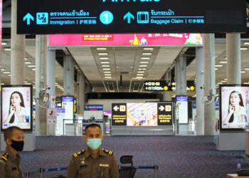 FILE PHOTO: FILE PHOTO: Immigration officers stand in front of an empty arrivals hall at Bangkok's Suvarnabhumi International airport amid the spread of the coronavirus disease (COVID-19), Thailand, June 3, 2020. REUTERS/Athit Perawongmetha/File Photo