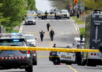Police officers work at the scene where police shot and injured a suspect who was walking down a city street carrying a gun, as four nearby schools were placed on lockdown, in Toronto, Ontario, Canada, May 26, 2022. REUTERS/Chris Helgren     TPX IMAGES OF THE DAY