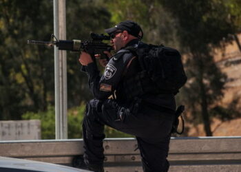 An Israeli police officer points his gun, at the scene of a shooting attack at Tekoa Junction in the Israeli-occupied West Bank, July 16, 2023. REUTERS/Dedi Hayun