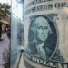 People walk past a currency exchange point, displaying an image of the U.S. dollar, in Cairo, Egypt, March 6, 2024. REUTERS/Mohamed Abd El Ghany