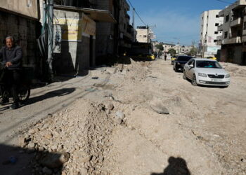 Cars drive along a damaged road, following a military operation by the Israeli army, in Jenin camp, in the Israeli-occupied West Bank, March 13, 2024. REUTERS/Raneen Sawafta