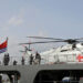 Visitors stand near a transport helicopter on the Kekexilihu, a Type 903 comprehensive supply ship, as the Chinese People's Liberation Army (PLA) Navy opens warships for public viewing to mark its upcoming 75th founding anniversary, at the port in Qingdao, Shandong province, China April 20, 2024. REUTERS/Florence Lo