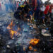 Palestinians search for food among burnt debris in the aftermath of an Israeli strike on an area designated for displaced people, in Rafah in the southern Gaza Strip, May 27, 2024. REUTERS/Mohammed Salem