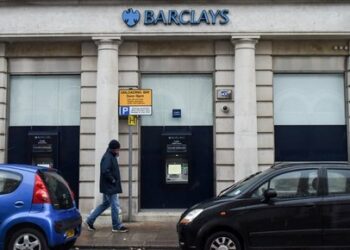 A man walks past a Barclays bank, in the Channel island's port capital Saint Helier, on December 11, 2022. (Photo by Sebastien SALOM-GOMIS / AFP)