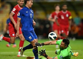 Singapore's goalkeeper Hassan Sunny (R) tries to save the ball from Thailand's Suphanat Mueanta (2nd L) during the 2026 FIFA World Cup AFC qualifiers football match between Thailand and Singapore at Rajamangala Stadium in Bangkok on June 11, 2024. (Photo by MANAN VATSYAYANA / AFP)