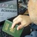 A Moroccan man holds his passport in front of his computer displaying a Schengen visa in the capital Rabat, on September 28, 2021. Paris will sharply reduce the number of visas granted to people from Algeria, Morocco and Tunisia, accusing the former French colonies of not doing enough to allow illegal immigrants to return, a government spokesman said today. (Photo by FADEL SENNA / AFP)