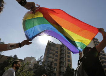 FILE - Activists from the Lesbian, Gay, Bisexual, and Transgender (LGBTQ) community in Lebanon shout slogans and hold up a rainbow flags as they march calling on the government for more rights in the country gripped by economic and financial crisis during ongoing protests, in Beirut, Lebanon, June 27, 2020. Security agencies and government officials across several countries in the Middle East and North Africa have been using social media platforms and mobile dating apps to track and crack down on LGBTQ people, international rights group Human Rights Watch said Tuesday, Feb. 21, 2023. (AP Photo/Hassan Ammar, File)