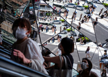 FILE PHOTO: People wearing protective masks are reflected in the mirror at a shopping mall in Tokyo, Japan, August 19, 2021. REUTERS/Athit Perawongmetha/File Photo