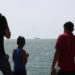 Palestinian youths stand on a jetty in Gaza City with a view of navy vessels off the coast as part of a humanitarian "maritime corridor" announced by US Central Command (CENTCOM) on May 17, 2024 amid the ongoing conflict in the Gaza Strip between Israel and Hamas. The US military said aid deliveries began on May 17 via a temporary pier in Gaza aimed at ramping up emergency humanitarian assistance to the war-ravaged Palestinian territory. (Photo by AFP)