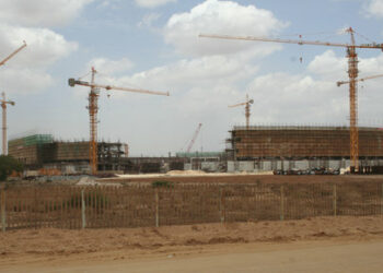 Construction work continues at the site of a soccer stadium for use in next year's African Nations Cup in the small town of Camama in this picture taken February 13, 2009. In a year in which Angola's two main exports -- oil and diamonds -- have plunged, a scene on the outskirts of the capital city of Luanda defies the notion of scaling back in bad times. Over the last few months, a massive 50,000-seater soccer stadium has risen in Camama where thousands of people live in shanty towns without running water or electricity. Picture taken February 13. To match feature SOCCER/ANGOLA    REUTERS/Henrique Almeida (ANGOLA)