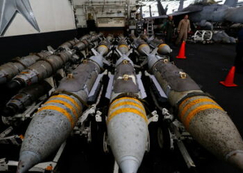 U.S Navy staff members walk next to aerial bombs at the hanger-bay aboard the USS Dwight D. Eisenhower (CVN 69) aircraft carrier in Southern Red Sea, Middle East, February 13, 2024. REUTERS/Hamad I Mohammed