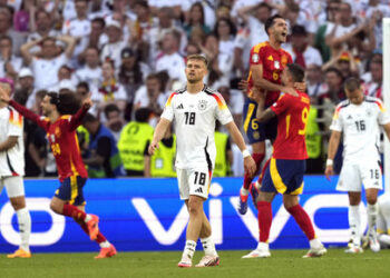 Germany's Maximilian Mittelstadt (18) reacts as Spain players celebrate after a quarterfinal match between Germany and Spain at the Euro 2024 soccer tournament in Stuttgart, Germany, Friday, July 5, 2024. (AP Photo/Antonio Calanni)