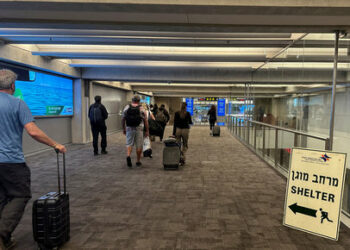 FILE PHOTO: People walk next to a sign directing for Shelter after landing in Israel at the arrivals section of Ben Gurion International airport in Lod near Tel Aviv, Israel  October 11, 2023 REUTERS/Marius Bosch/File Photo