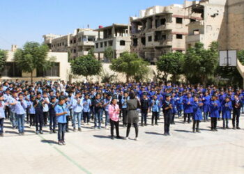 Students gesture as they stand together at the playground of Mleiha rural school, in Mleiha, Syria, September 14, 2021. Picture taken September 14, 2021. REUTERS/Firas Makdesi