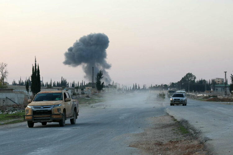 Anti-regime fighters drive along the Aleppo- Damascus M5 international highway in the newly captured northwestern area of Khan al-Assal, as smoke rises in the distance on November 29, 2024. Jihadists and their Turkish-backed allies took control of five districts of Syria's second city of Aleppo on November 29, "without any significant pushback" from the Syrian military, a war monitor said. (Photo by AFP)