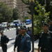 Police officers watch as a convoy carrying members of the British media leaves the British Embassy in Tehran, Iran August 23, 2015.  Britain reopened its embassy in Tehran on Sunday, nearly four years after protesters ransacked the ambassador's residence and burned the Union Jack. In a signal of the most striking thaw in Western ties with Iran for over a decade, Foreign Secretary Philip Hammond watched the British flag being raised in the garden of the opulent 19th century building while the national anthem played.   REUTERS/Darren Staples