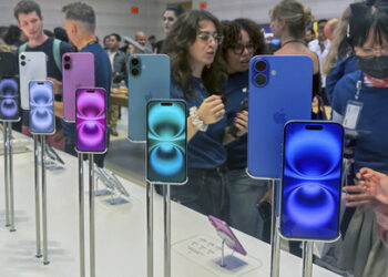 FILE - People gather near a display of iPhone 16's at the Apple Store on 5th Ave. in New York on September 20, 2024.(AP Photo/Ted Shaffrey, File)