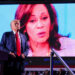 Republican presidential nominee and former U.S. President Donald Trump looks on as Democratic presidential nominee and U.S. Vice President Kamala Harris' face appears as a video plays on a screen, during a rally at Huntington Place in Detroit, Michigan, U.S. October 18, 2024.  REUTERS/Brian Snyder