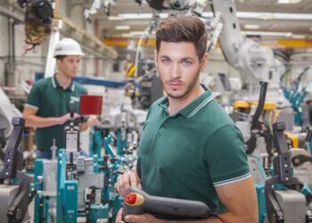 technician team while robot maintenance in a welding shop of a car manufacture