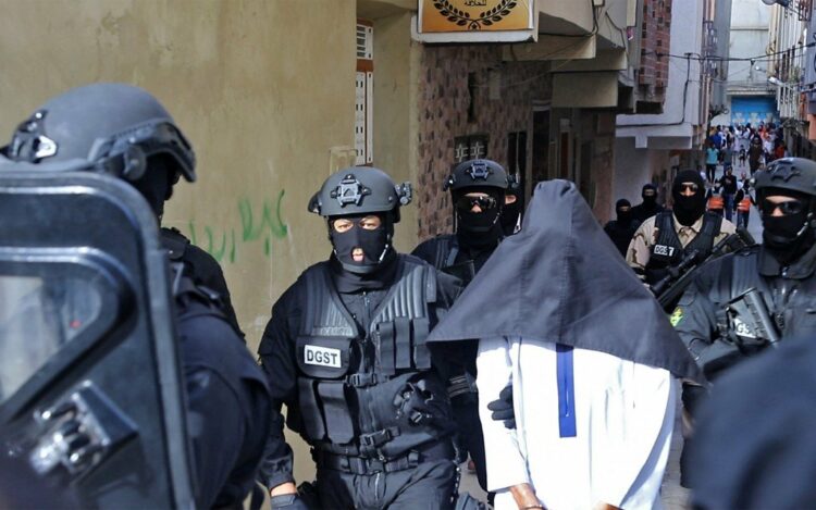 Members of Moroccos's Central Bureau of Judicial Investigation (BCIJ), which oversees counter-terrorism operations, escort a suspect outside a house in the city of Tangier, on October 6, 2021. (Photo by AFP)