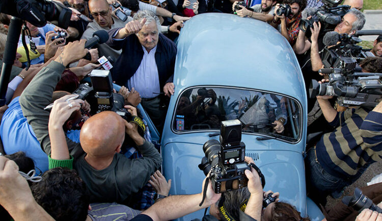 Uruguay's President Jose Mujica, center, leaves after casting his vote during general elections in Montevideo, Uruguay Sunday, Oct. 26, 2014. Uruguay’s presidential election is set to go into a runoff as undecided voters could opt for change on Sunday, despite an economic boom and social reforms led by the ruling Broad Front coalition. (AP Photo/Natacha Pisarenko)